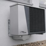 Outdoor air conditioning unit mounted on a residential building exterior.