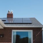 brown brick house with solar panels on roof