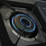 Close-up of a gas stove burner with blue flame